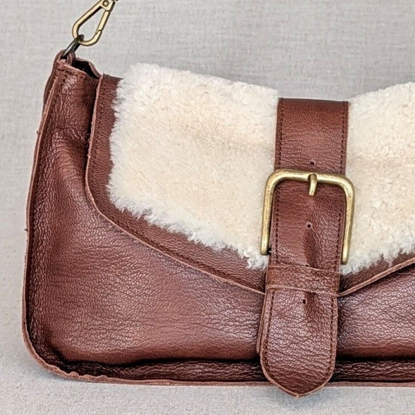 olso ADDY de napa de cordero Belice — solapa hair-on — bolso compacto con bandolera regulable — color marrón