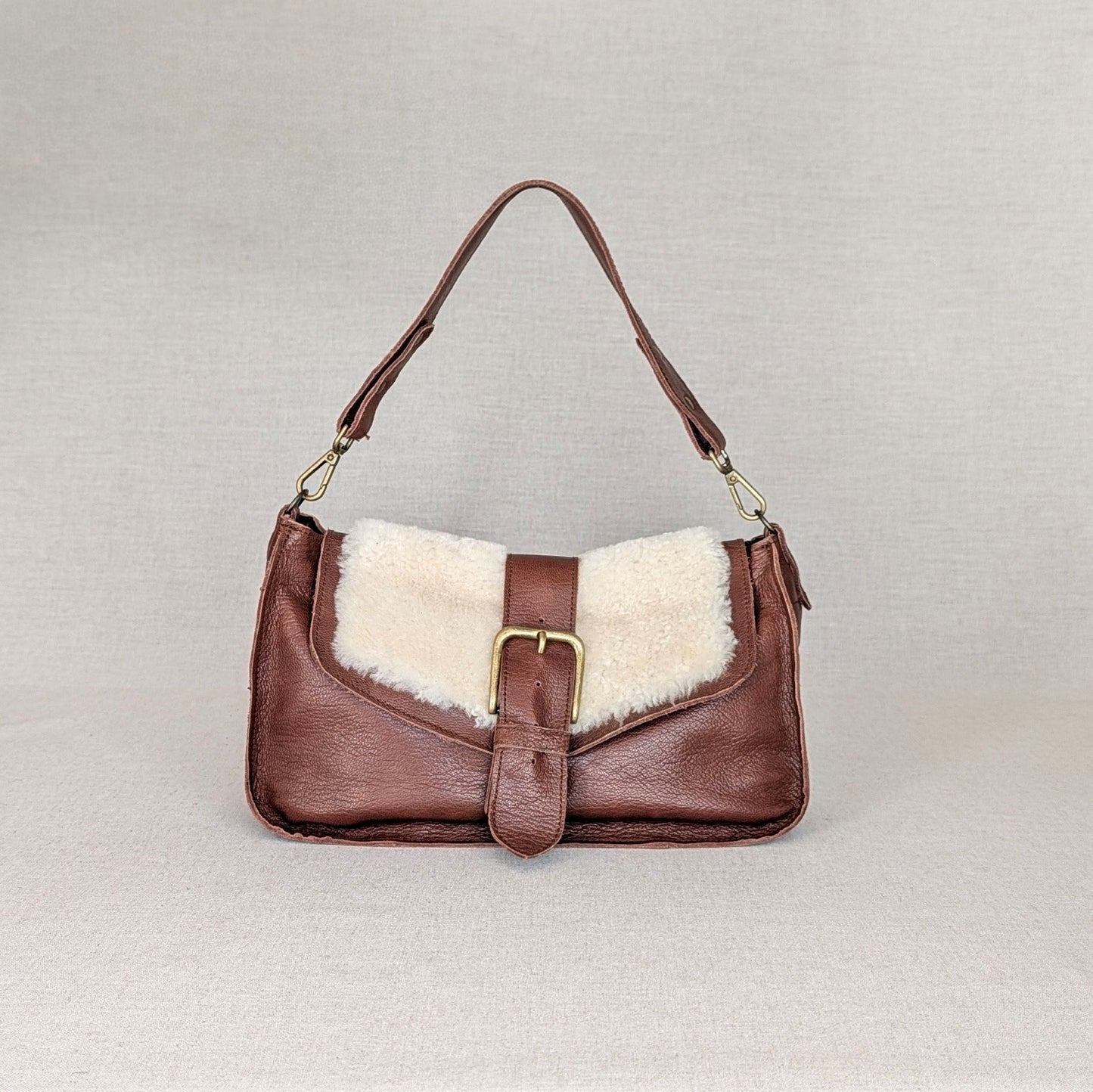 Bolso ADDY de napa de cordero Belice — solapa hair-on — bolso compacto con bandolera regulable — color marrón